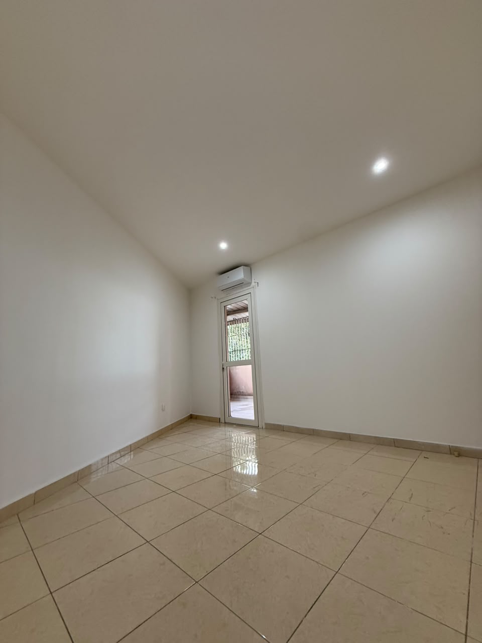 Chambre livrée, murs blancs, plafond avec spots, climatiseur et carrelage nettoyé
