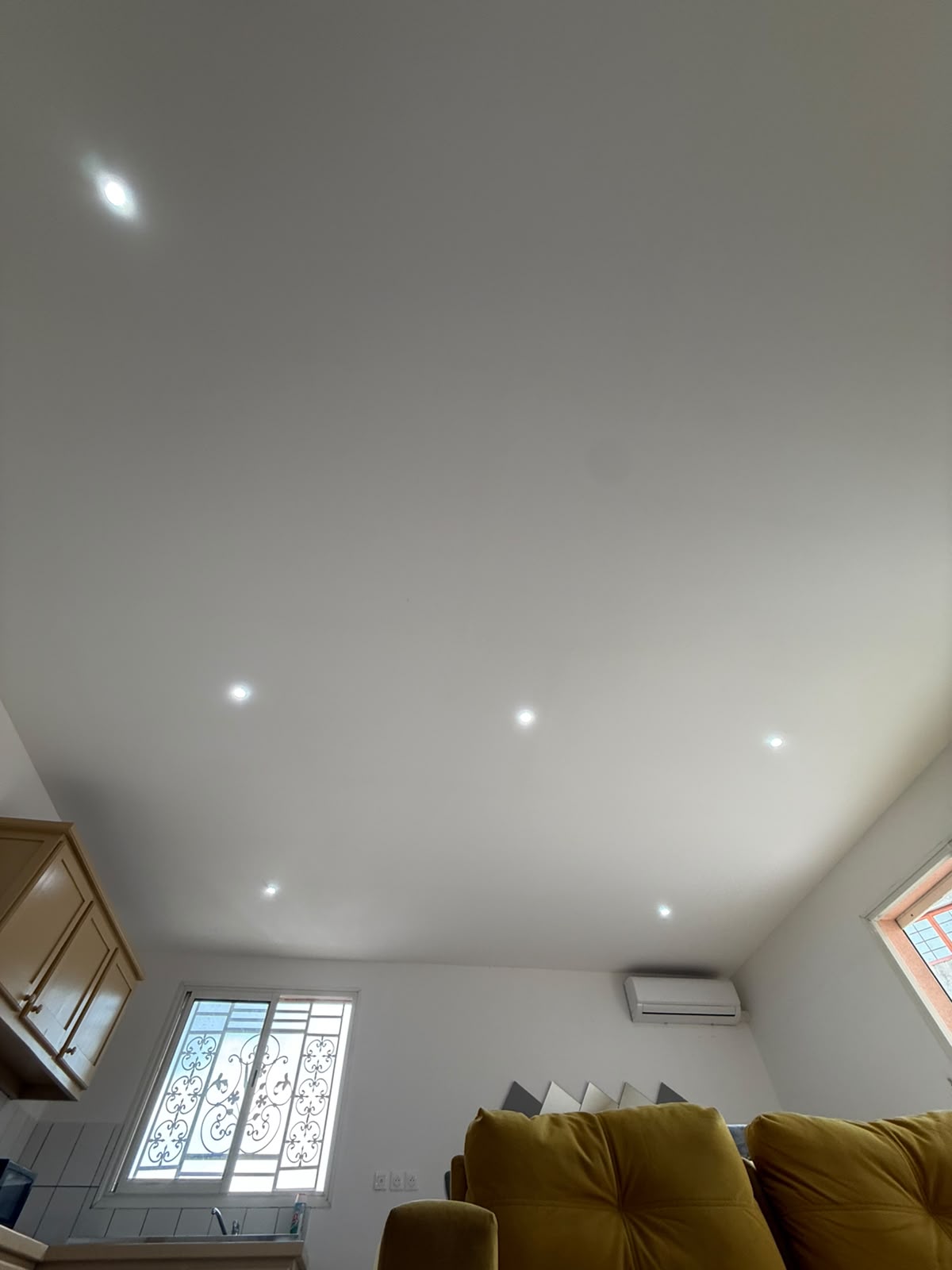 Plafond terminé, blanc et plan, avec spots encastrés alignés