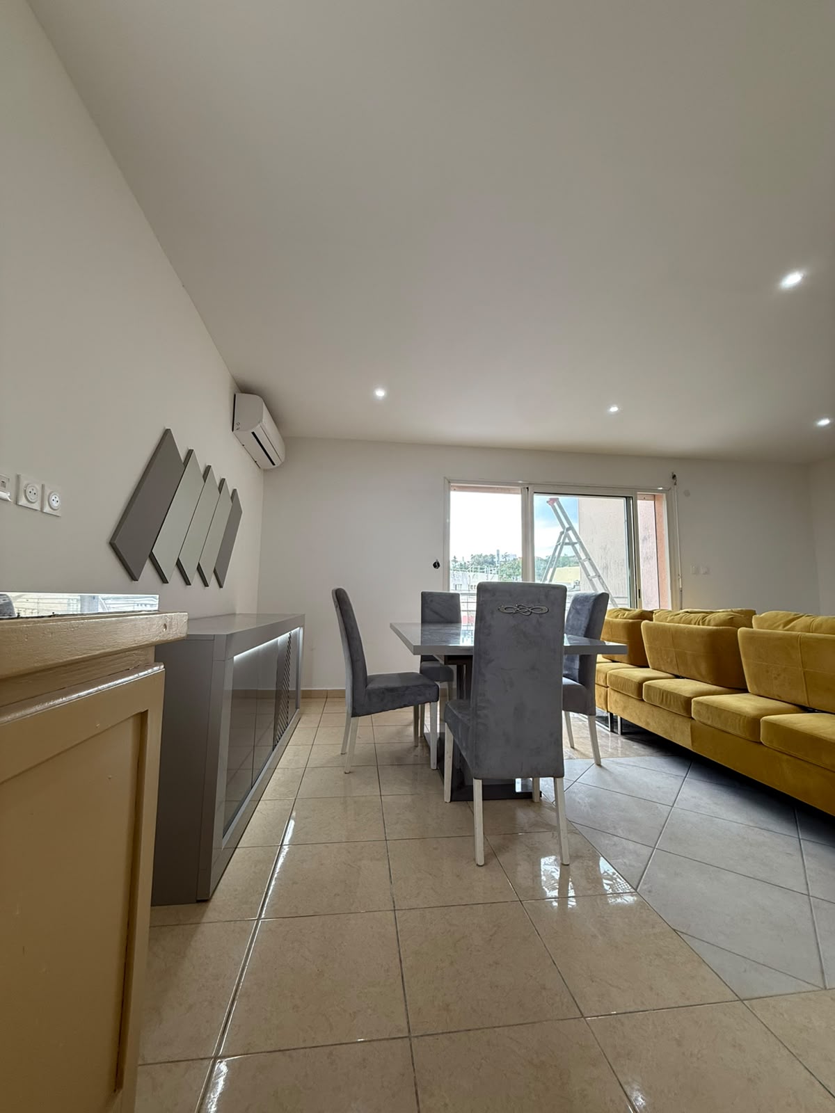 Coin repas avec buffet, climatiseur et décoration murale